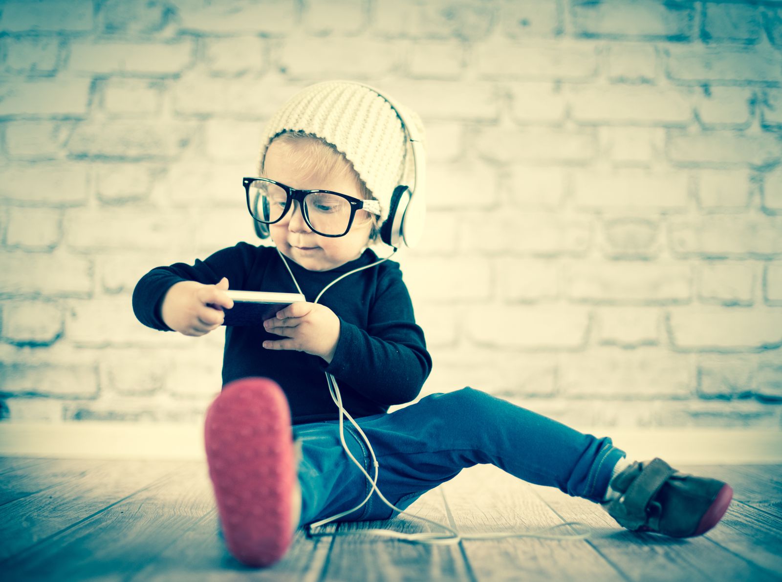 Child with glasses listening to music on an iPod